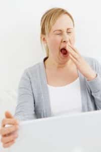 Yawning woman with laptop - needs more sleep!